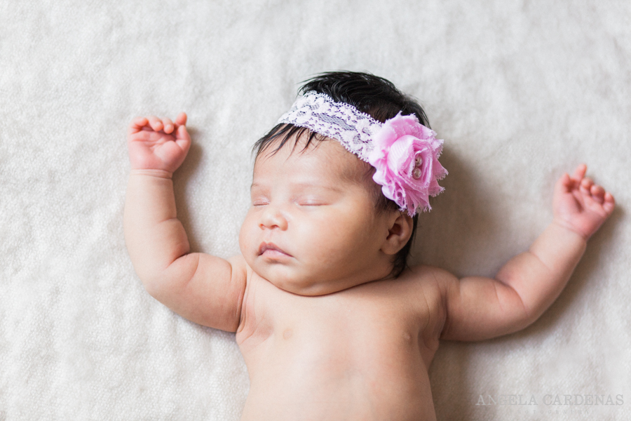 baby girl sleeping with open arms and headband